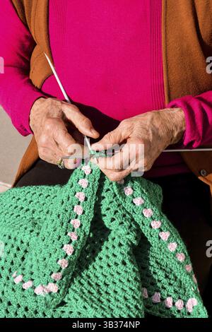 Image en gros plan d'une vieille femme avec des aiguilles à tricoter et de la laine Banque D'Images