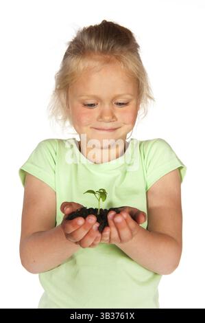 Portrait petit bambin blond surpris par la croissance jeune plante de la nature Banque D'Images