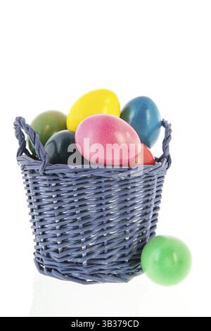 Les oeufs de Pâques colorés dans panier isolé sur fond blanc Banque D'Images