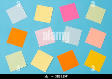 Papiers de notes colorés, collection de différentes feuilles colorées sur fond bleu, texte de votre message, rappel Banque D'Images