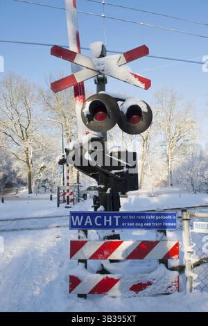 Feux rouges avec de la neige du passage à niveau de chemin de fer Banque D'Images