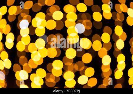 Lumières bokeh dorées sur fond sombre Banque D'Images