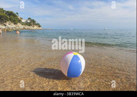Ballon de plage gonflable coloré jouant avec le surf et la mer Banque D'Images
