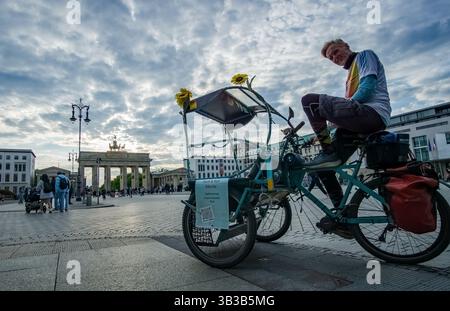 Le chauffeur de pousse-pousse attend les nouveaux passagers près de la porte de Brandebourg, une attraction touristique populaire et un point de repère sur la Pariser Platz à Berlin. Banque D'Images
