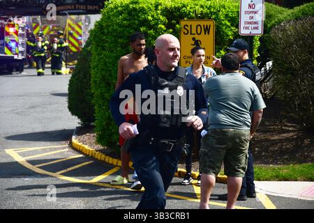RACE : un incendie de maison menace de se propager à celui des maisons voisines alors que l'équipe d'intervention d'urgence travaille dur pour protéger la communauté du danger. Banque D'Images
