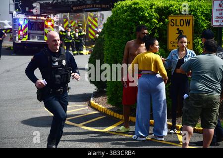 RACE : un incendie de maison menace de se propager à celui des maisons voisines alors que l'équipe d'intervention d'urgence travaille dur pour protéger la communauté du danger. Banque D'Images