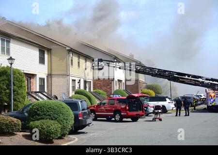 RACE : un incendie de maison menace de se propager à celui des maisons voisines alors que l'équipe d'intervention d'urgence travaille dur pour protéger la communauté du danger. Banque D'Images