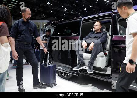 A foreign visitor learns about the Xinghai V9 new energy vehicle. Shanghai,China.26th April 2025. Foreign visitors learn about China's new energy vehicles at the 21st Shanghai International Automobile Industry Exhibition (Auto Shanghai) at the National Exhibition and Convention Center (Shanghai) on April 26, 2025. Credit: Yin Liqin/China News Service/Alamy Live News Stock Photo