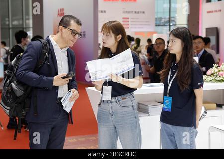 Un visiteur étranger discute avec le personnel lors de la 21ème exposition internationale de l'industrie automobile de Shanghai (Auto Shanghai). Shanghai, China.26th avril 2025. Les visiteurs étrangers découvrent les nouveaux véhicules énergétiques chinois lors de la 21e exposition internationale de l'industrie automobile de Shanghai (Auto Shanghai) au National Exhibition and Convention Center (Shanghai) le 26 avril 2025. Crédit : Yin Liqin/China News Service/Alamy Live News Banque D'Images