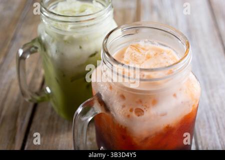 Une vue de deux versions de thé thaïlandais dans des pots mason en verre. Banque D'Images