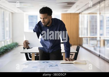 Professionnel africain concentré engagé dans l'analyse des données et la prise de décision Banque D'Images