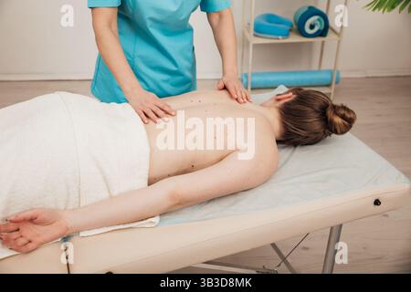 Femme thérapeute faisant massage médical relaxant du dos dans le spa Banque D'Images