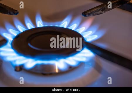 Brûleur de cuisinière à gaz domestique gros plan. Motif de flamme bleue, pas de gens. Banque D'Images