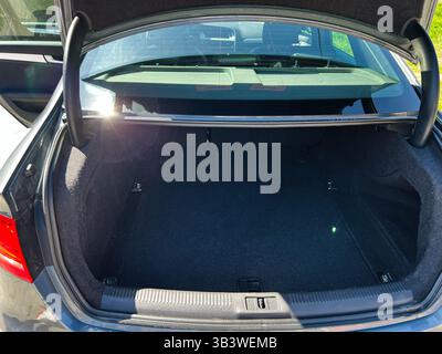 Kiev, Ukraine - 28 avril 2025 : coffre de voiture Audi A4 ouvert présentant un grand espace de chargement noir vide à l'intérieur d'un véhicule. Banque D'Images