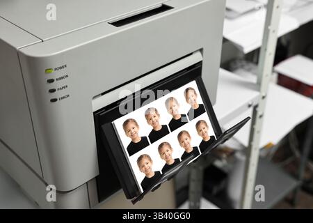 Imprimante moderne avec des photos de passeport de l'enfant à l'intérieur, gros plan Banque D'Images
