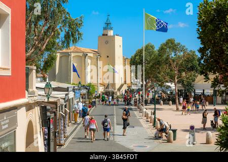 Les gens se promènent le long de la passerelle pavée par une journée d'été ensoleillée dans le centre de Port Grimaud, France. Banque D'Images