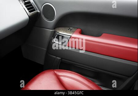 Intérieur en cuir rouge de la voiture moderne de luxe. Cuir rouge perforé. Sièges avec fond de couture. Détails intérieurs de voiture modernes. Voiture à l'intérieur Banque D'Images