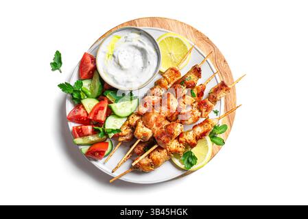 Kebabs souvlaki de poulet grillé avec salade de légumes frais et trempette labneh isolé sur fond blanc, vue de dessus. Déjeuner céto méditerranéen avec rôti Banque D'Images