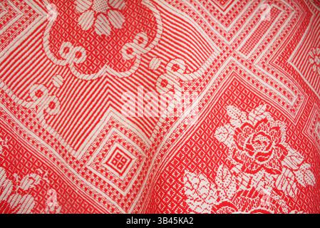 Motifs textiles rouges éclatants mettant en valeur des motifs floraux et géométriques complexes inspirés de l'artisanat traditionnel Banque D'Images