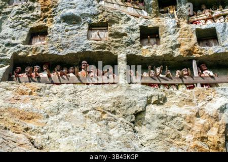 De spectaculaires effigies en bois grandeur nature ou tau tau des défunts sont nichées parmi les cryptes. Le site funéraire de Lemo est l'un des plus anciens sites de Toraja. Banque D'Images