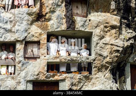 De spectaculaires effigies en bois grandeur nature ou tau tau des défunts sont nichées parmi les cryptes. Le site funéraire de Lemo est l'un des plus anciens sites de Toraja. Banque D'Images