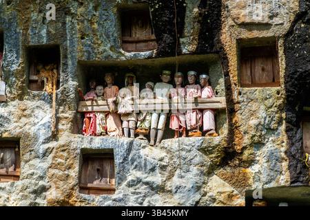 De spectaculaires effigies en bois grandeur nature ou tau tau des défunts sont nichées parmi les cryptes. Le site funéraire de Lemo est l'un des plus anciens sites de Toraja. Banque D'Images