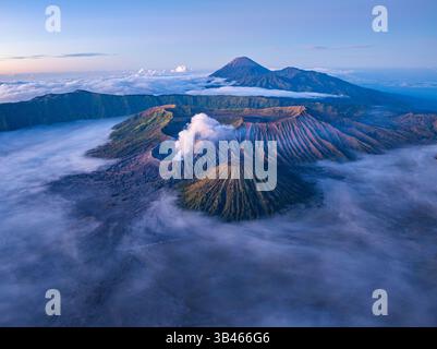 Vue aérienne du Mont bromo à couper le souffle entouré de brume et de paysages spectaculaires. Volcan actif en Indonésie, la douce lumière du matin se met en évidence Banque D'Images