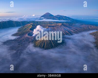 Vue aérienne du Mont bromo à couper le souffle entouré de brume et de paysages spectaculaires. Volcan actif en Indonésie, la douce lumière du matin se met en évidence Banque D'Images