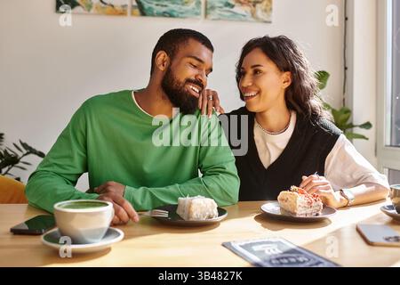 Un couple aime le dessert tout en riant et en se connectant dans une ambiance chaleureuse de café. Banque D'Images
