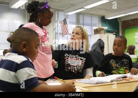 13 janvier 2015 - Jacksonville, Floride, États-Unis - MONICA HERNDON | Times .Assignment for Black Students Education Project :.Teacher Laurel Ledoux travaille avec Jackson Rowan, 7 (extrême gauche, rayures), Azaria Bell, 8 (rose), et Josiah Adams, 7 ans, (à droite, tortues mutantes) pendant un cours de mathématiques à l'école primaire Pine Forest dans le comté de Duval. Dans la classe de mathématiques et de sciences de deuxième année, les élèves étaient regroupés par niveau de compétence. Advanced table faisait des conversions de centimer-pouce tandis que les débutants faisaient des pouces en pieds, moyen faisaient des pouces et des yards. (Photo prise le 13/01/2015) (crédit image : © Monica Herndon/ Banque D'Images