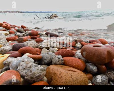 Surface très détaillée du mélange de galets créé par la force de l'eau. Le littoral de l'Ontario affiche une harmonie de couleurs façonnée par le temps et la marée. Banque D'Images