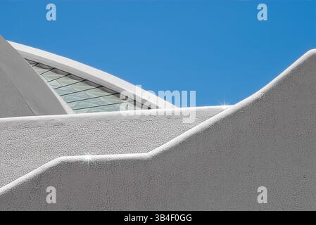 Les éléments architecturaux courbes contrastent d'un blanc éclatant avec un ciel bleu vif, mettant en valeur un design moderne avec des lignes nettes et une esthétique dynamique. Géo Banque D'Images