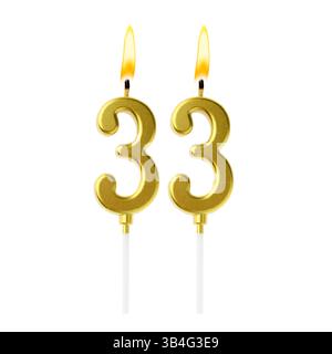 Bougies de gâteau dorées brûlantes composant le numéro 33 sur fond blanc. Décoration festive pour anniversaire ou autre date spéciale Banque D'Images