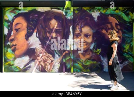 Femme regarde l'art mural à Wynwood Walls, Miami, Floride, États-Unis Banque D'Images