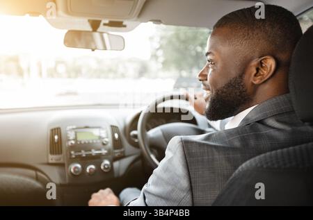 Vue arrière de la voiture d'homme d'affaires noir heureux Banque D'Images