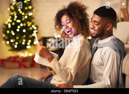 Heureux couple afro-américains à la maison cadeaux de Noël Banque D'Images