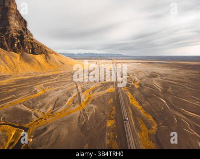 Vue aérienne de haut en bas véhicule conduite sur la rocade sud islandaise avec des montagnes pittoresques et un panorama de paysage sauvage en arrière-plan. Islande Road trip con Banque D'Images
