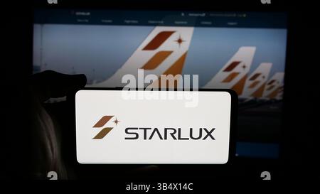Dans cette illustration photo, une personne tient un téléphone portable avec le logo de la compagnie aérienne taïwanaise Starlux Airlines sur l'écran en face de la page Web. (Photo timon Schneider / SOPA images/SIPA USA) *** strictement à des fins éditoriales *** Banque D'Images