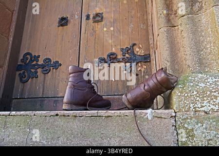 Une paire de bottes de marche sur les marches d'une église ou d'un vieux bâtiment classique Banque D'Images