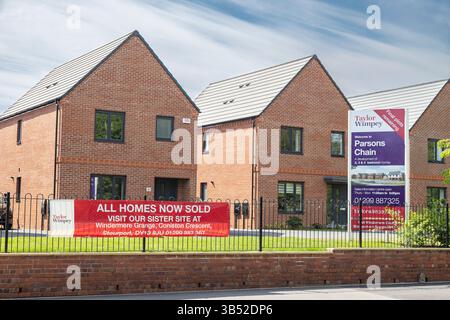 Taylor Wimpey, toutes les maisons maintenant vendues, signe devant les maisons neuves. Banque D'Images