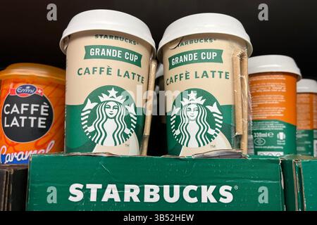 Deux boissons Starbucks Grande Cup Caffe Latte en vente sur une étagère de supermarché. 13 mars 2025. Banque D'Images