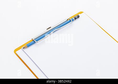 Presse-papiers et crayon : un gros plan d'un presse-papiers vide, avec un crayon posé dessus, symbolisant le début de l'écriture créative, collecte de données Banque D'Images