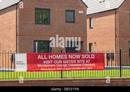 Taylor Wimpey, toutes les maisons maintenant vendues, signe devant les maisons neuves. Banque D'Images