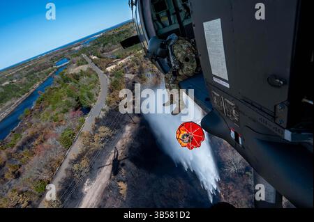 Forked River, New Jersey, États-Unis. 28 avril 2025. Timothy Witts, un chef d'équipage du 1er Bataillon du 150th Assault Helicopter Regiment de la Garde nationale de l'armée du New Jersey, utilise le système Bambi Bucket pour éteindre les flammes d'un UH-60M Black Hawk dans Ocean County, New Jersey, avril 28, 2025. Les soldats de la Garde nationale du New Jersey, les aviateurs et les fonctionnaires de l'État ont répondu aux demandes de soutien aux efforts en cours pour contenir les 000 acres de feu de forêt dans Ocean County, New Jersey. (Crédit image : © Michael Schwenk/U.S. Army/ZUMA Press Wire) USAGE ÉDITORIAL UNIQUEMENT ! Non destiné à UN USAGE commercial ! Banque D'Images
