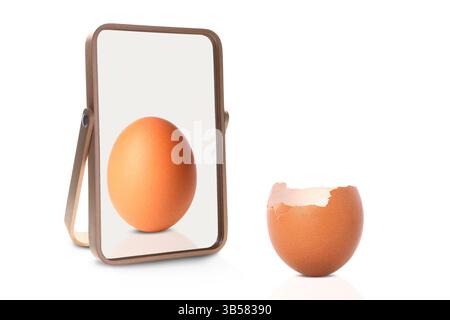 Oeuf craqué reflétant dans le miroir dans son ensemble, fond blanc. Opposé, contraste, différence Banque D'Images