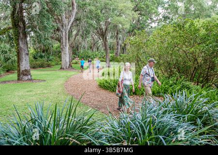 Lac de Galles Floride, Bok Tower Gardens, homme couple femme, adultes seniors marchant ensemble, chemin bordé d'arbres, sentier de la nature, jardin paysager pittoresque, paisible ou Banque D'Images