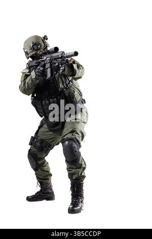 Un soldat tactique en uniforme complet, équipé d'un équipement de protection et d'une arme à feu, prêt et prêt avec une position professionnelle, isolé contre un nettoyage Banque D'Images