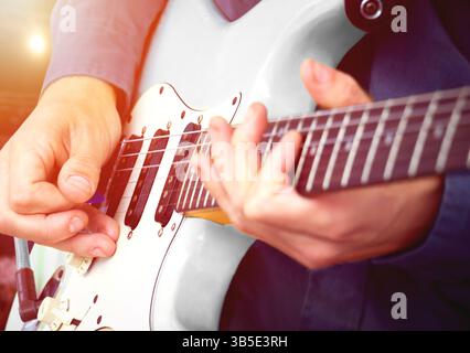Performance musicale live par guitariste – musicien jouant de la guitare électrique contre les lumières de scène dans la salle de concert. Banque D'Images