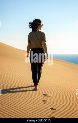 Femme marchant pieds nus sur les dunes de sable de la plage de Patara en Turquie Banque D'Images