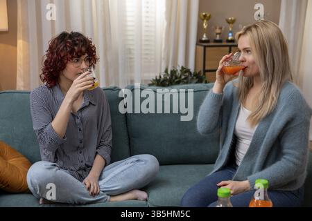 Deux amis se livrant à des boissons rafraîchissantes tout en créant une atmosphère chaleureuse et accueillante dans un salon élégant Banque D'Images
